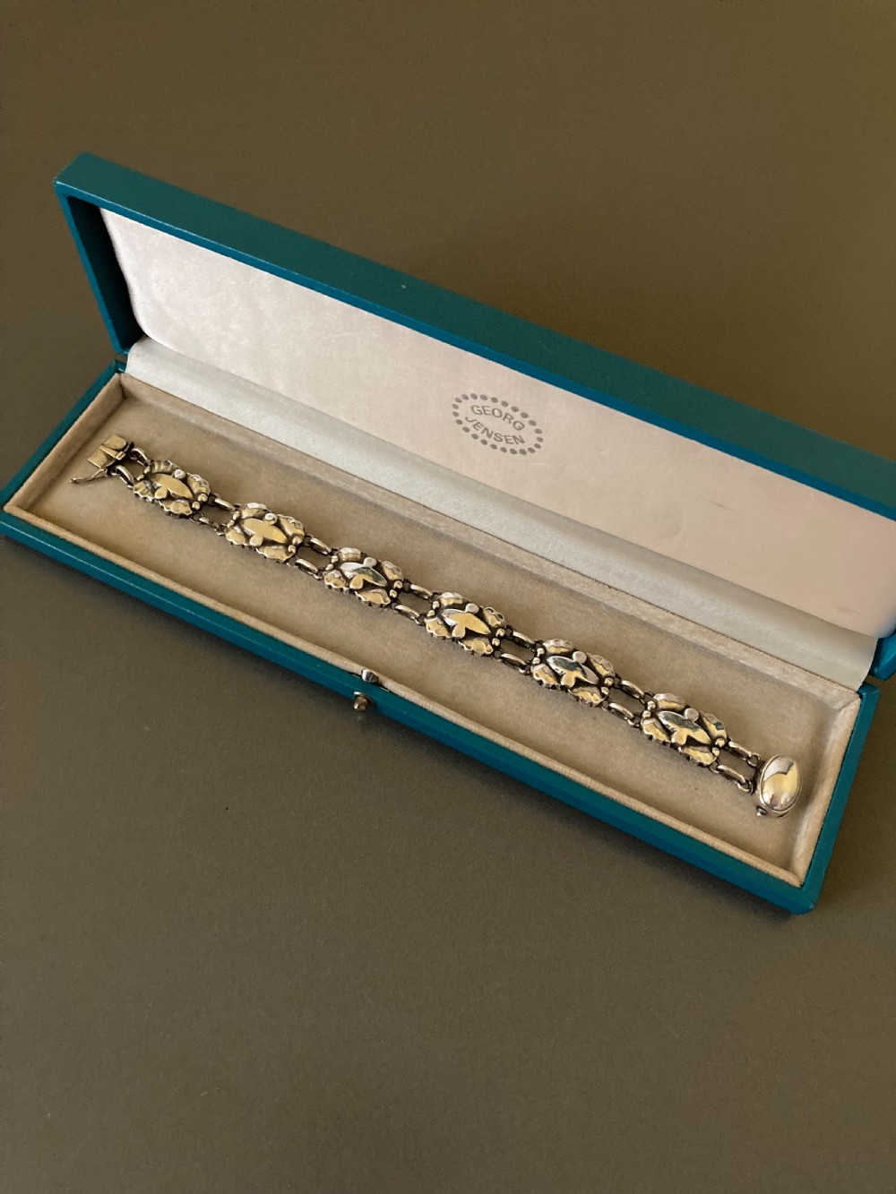 A vintage Georg Jensen sterling silver link bracelet featuring repeating organic floral motifs and a secure clasp. View VI