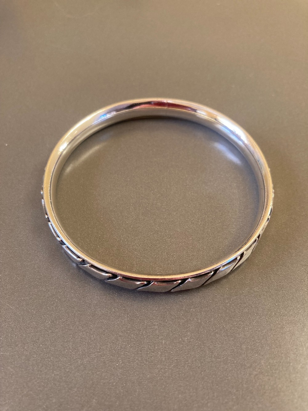 A 1960s Danish sterling silver bangle featuring a carved geometric pattern around the exterior band. View II