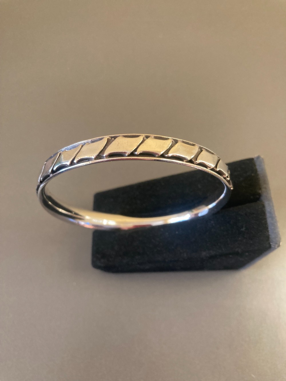 A 1960s Danish sterling silver bangle featuring a carved geometric pattern around the exterior band. View IV