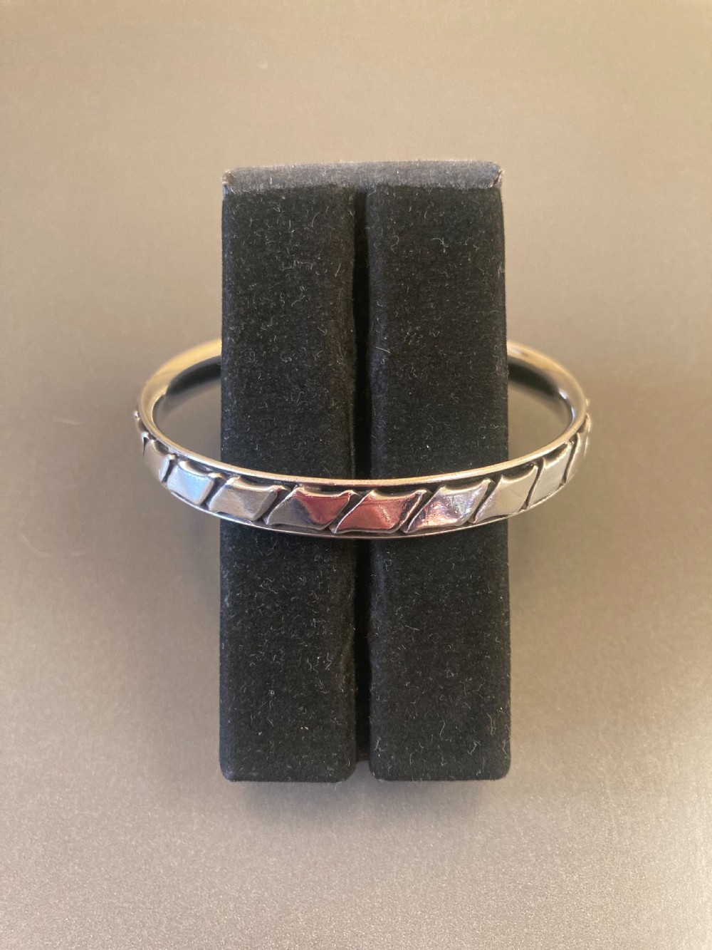 A 1960s Danish sterling silver bangle featuring a carved geometric pattern around the exterior band. View VI