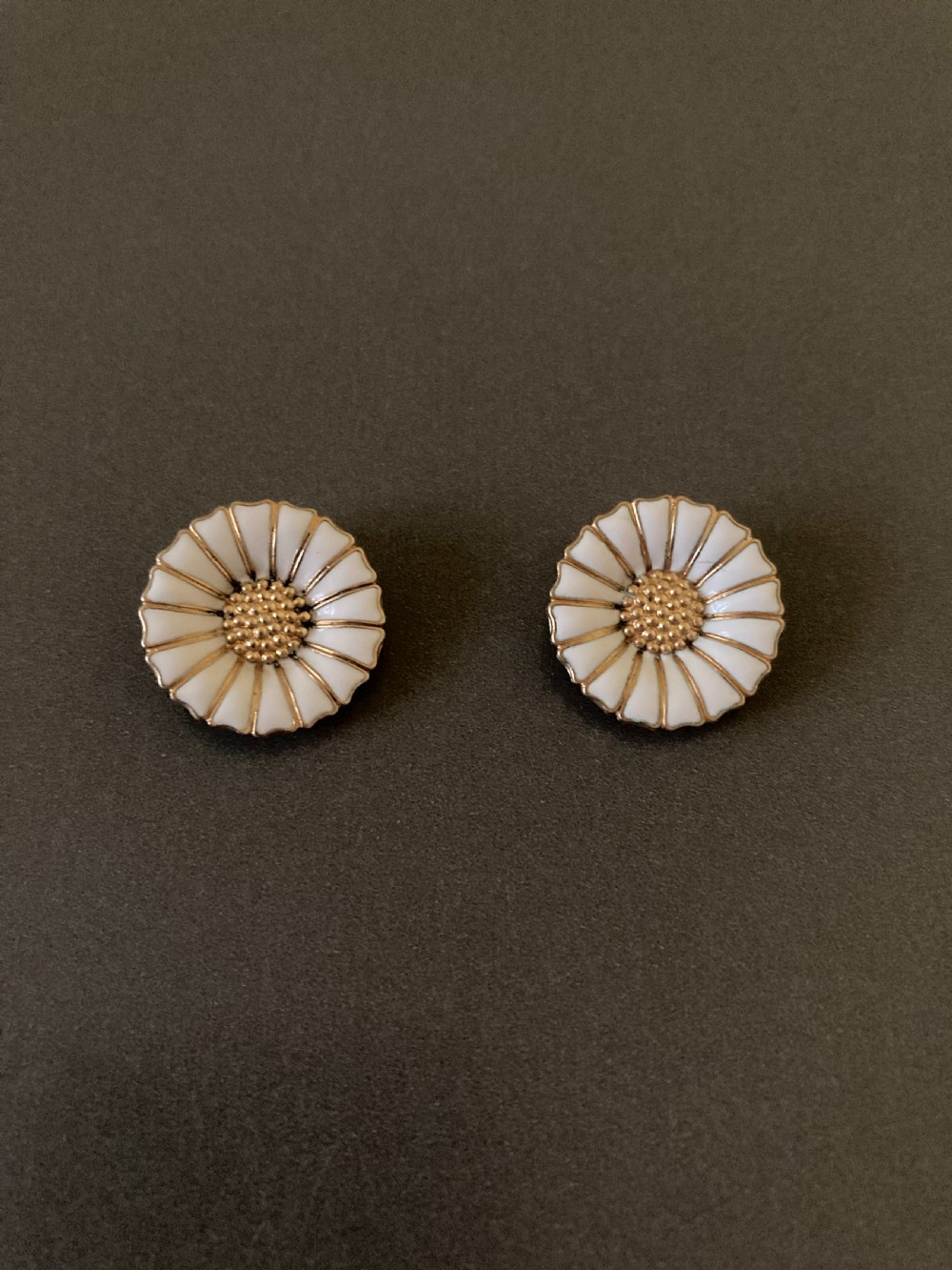 A pair of vintage Danish silver gilt daisy earrings featuring white enamelled petals and a textured gold centre.