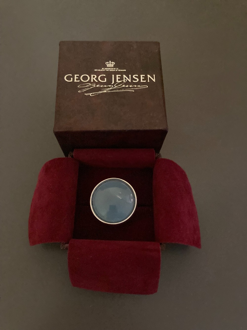 A vintage Georg Jensen sterling silver ring featuring a smooth, round blue chalcedony cabochon set in a minimalist bezel. View IV