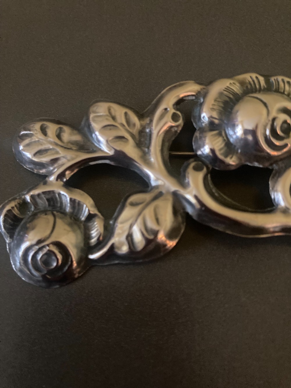 A 1920s Danish silver brooch featuring an openwork floral design of three sculpted rose blossoms and leaves. View III