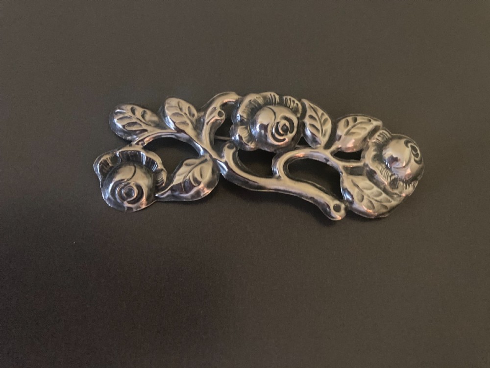 A 1920s Danish silver brooch featuring an openwork floral design of three sculpted rose blossoms and leaves. View IV
