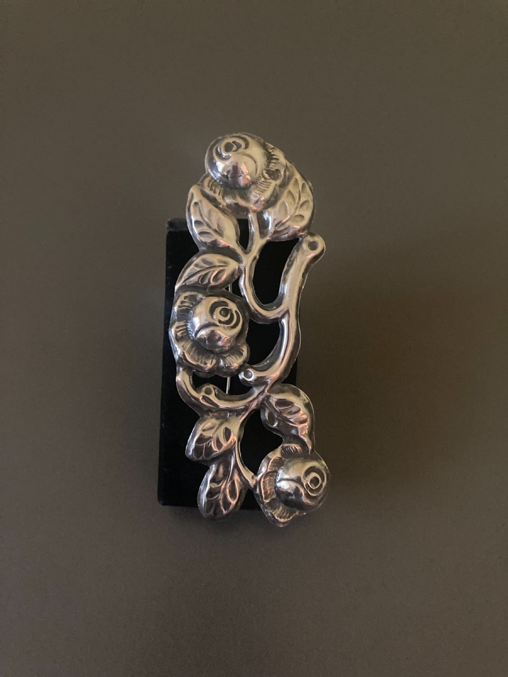 A 1920s Danish silver brooch featuring an openwork floral design of three sculpted rose blossoms and leaves. View V