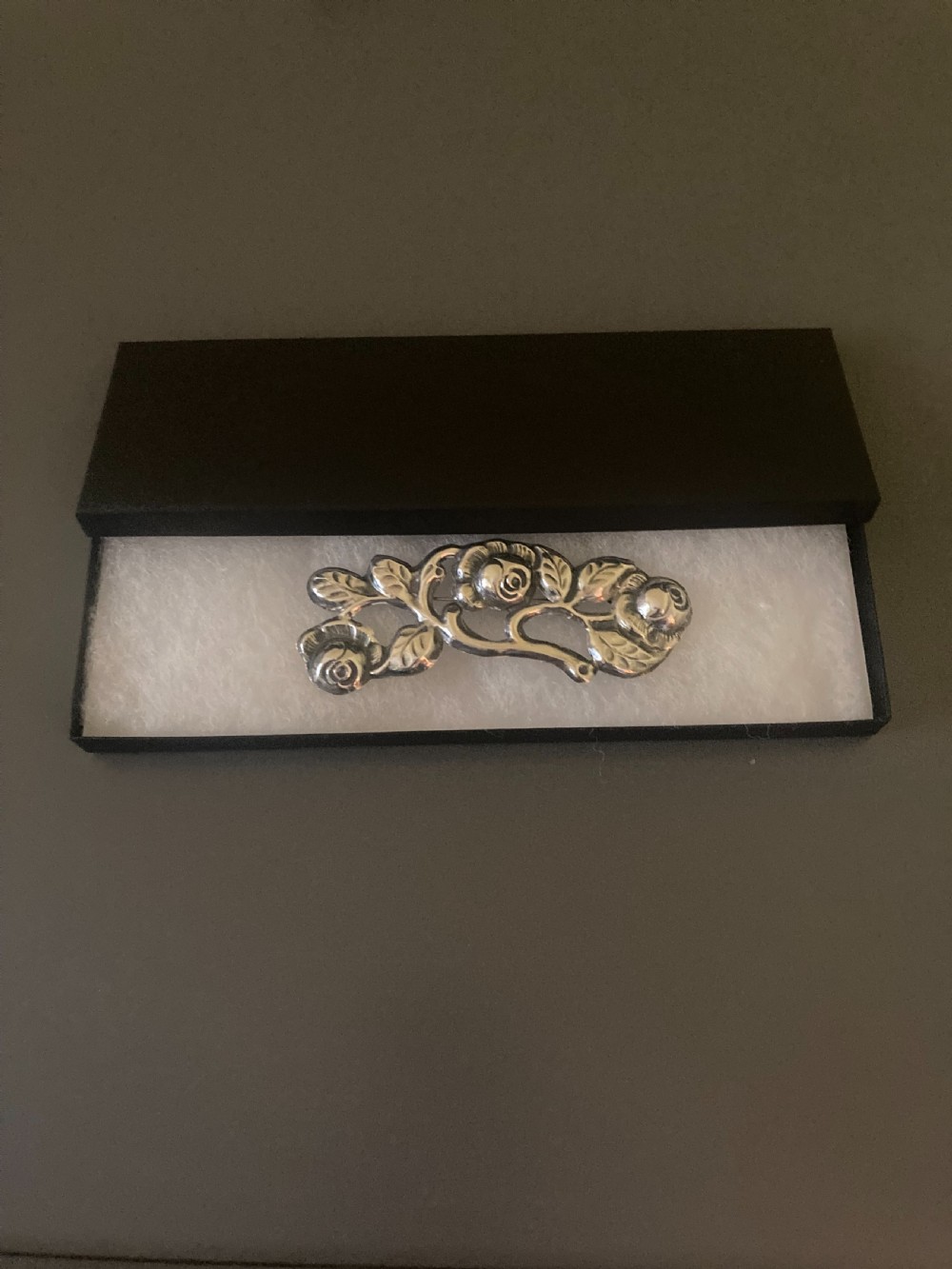 A 1920s Danish silver brooch featuring an openwork floral design of three sculpted rose blossoms and leaves. View VI