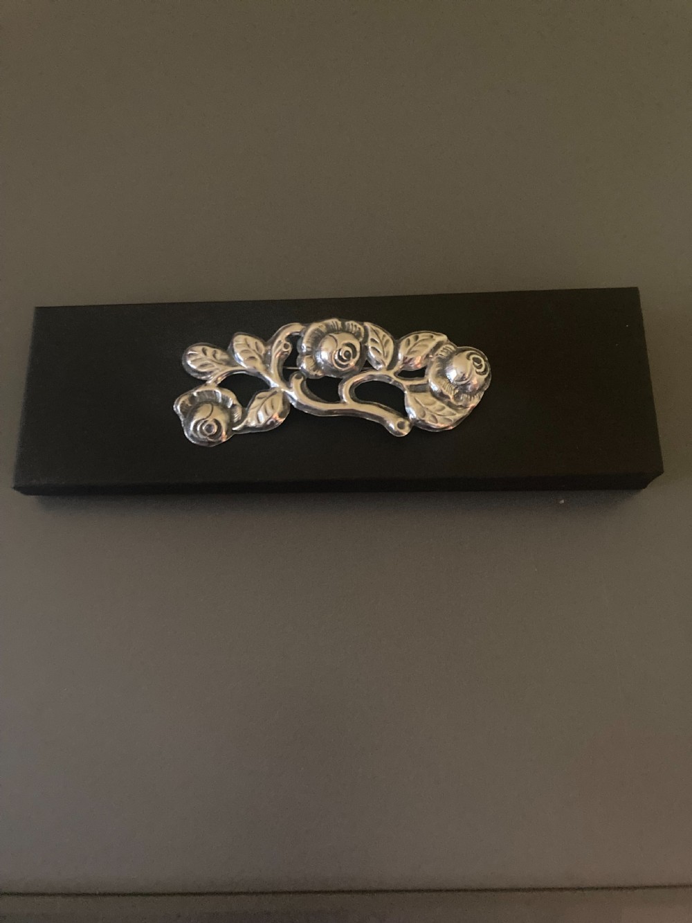 A 1920s Danish silver brooch featuring an openwork floral design of three sculpted rose blossoms and leaves. View VII