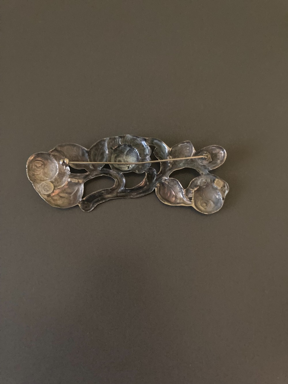 A 1920s Danish silver brooch featuring an openwork floral design of three sculpted rose blossoms and leaves. View VIII