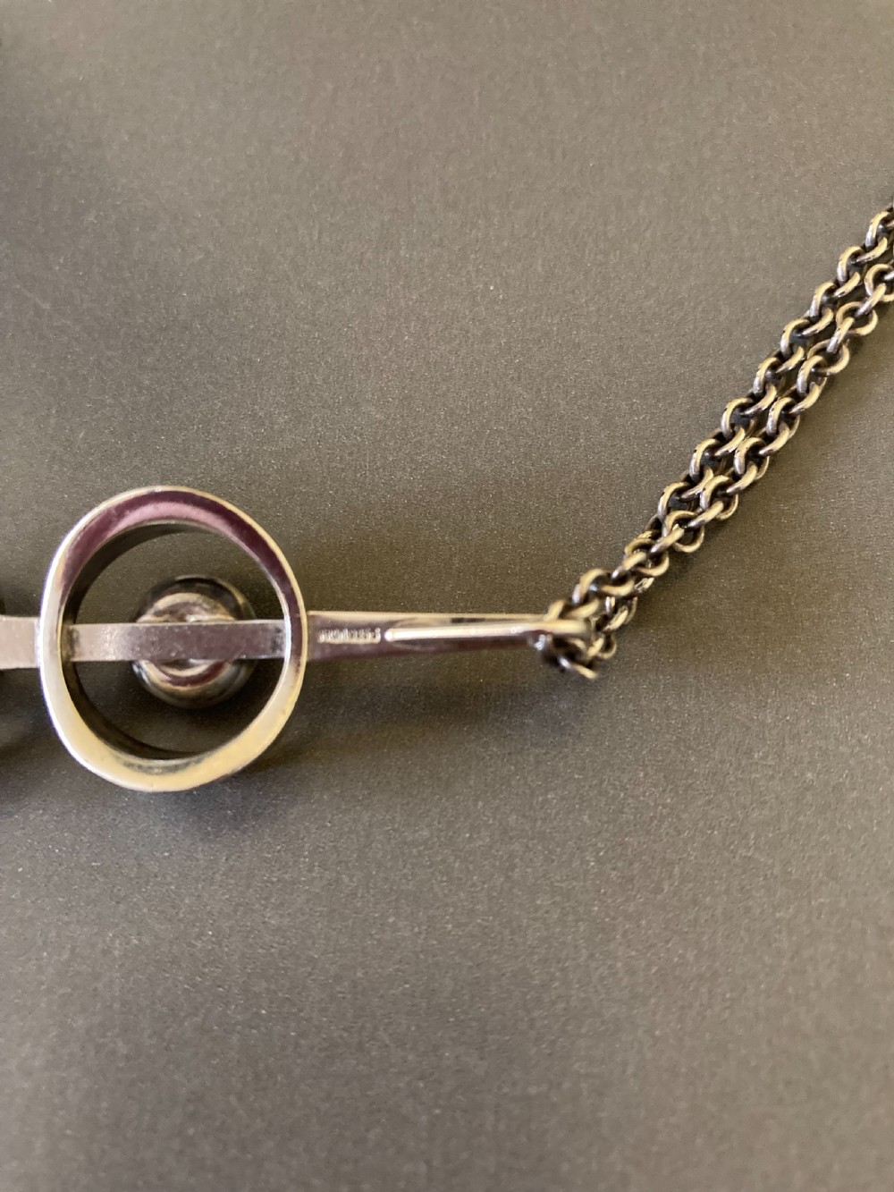 A vintage Danish modernist sterling silver pendant featuring two circular elements set with cabochon amethysts, suspended from a matching silver chain. View V