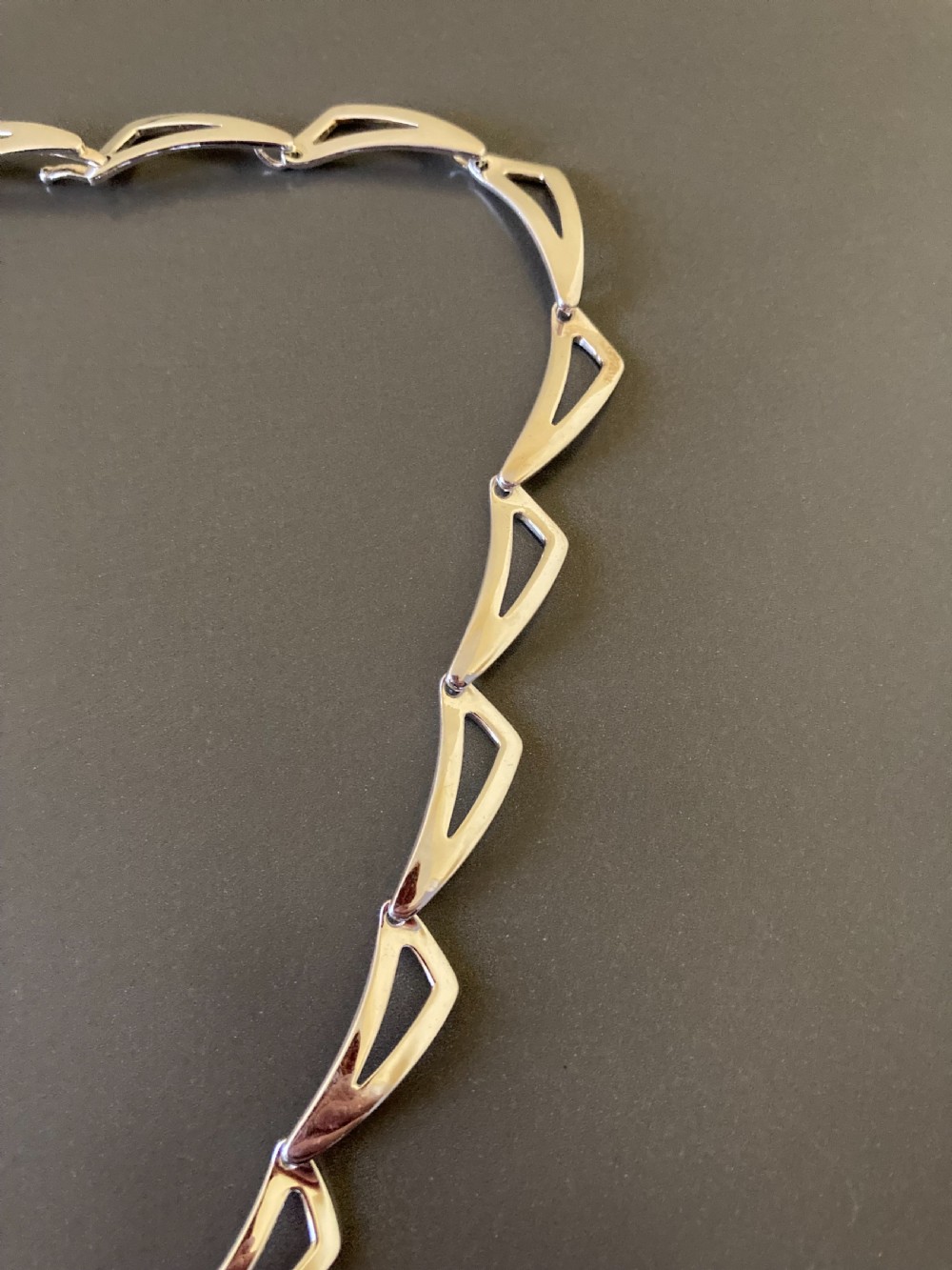 A vintage 1960s Danish sterling silver necklace featuring an articulated sequence of open triangular geometric links. View III