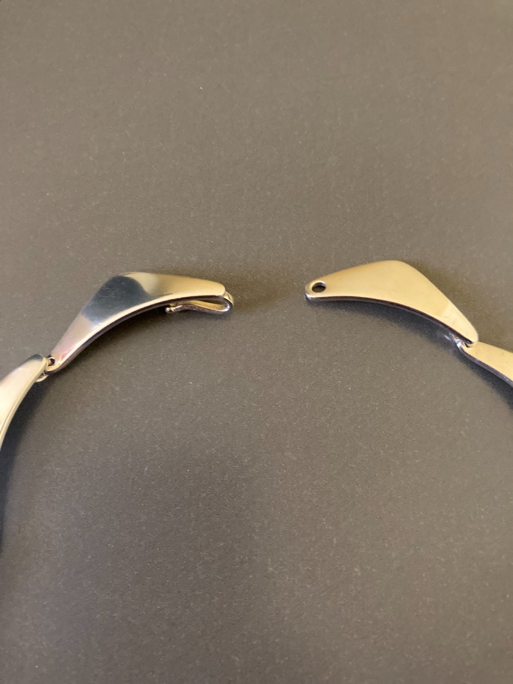 A vintage Danish silver link necklace featuring geometric, articulated segments arranged in a circular design. View VII