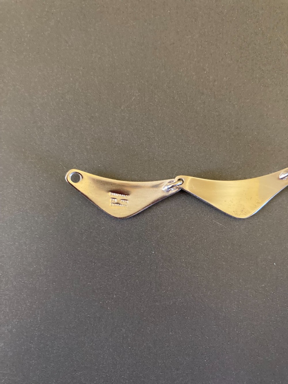 A vintage Danish silver link necklace featuring geometric, articulated segments arranged in a circular design. View VIII