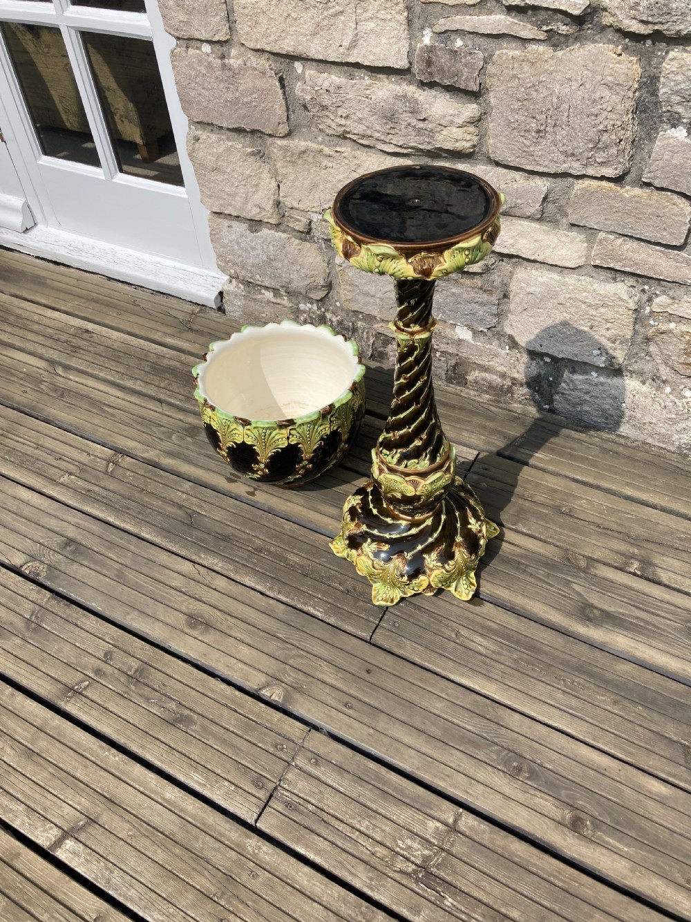 An Art Nouveau majolica ceramic jardiniere resting on a tall twisted pedestal stand decorated with dark brown glaze and raised green acanthus leaf relief motifs. View IV
