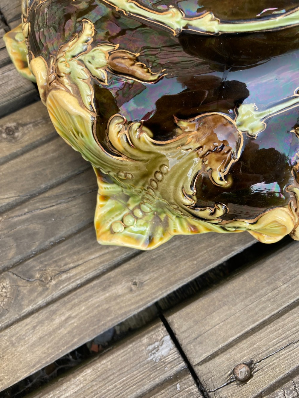 An Art Nouveau majolica ceramic jardiniere resting on a tall twisted pedestal stand decorated with dark brown glaze and raised green acanthus leaf relief motifs. View V
