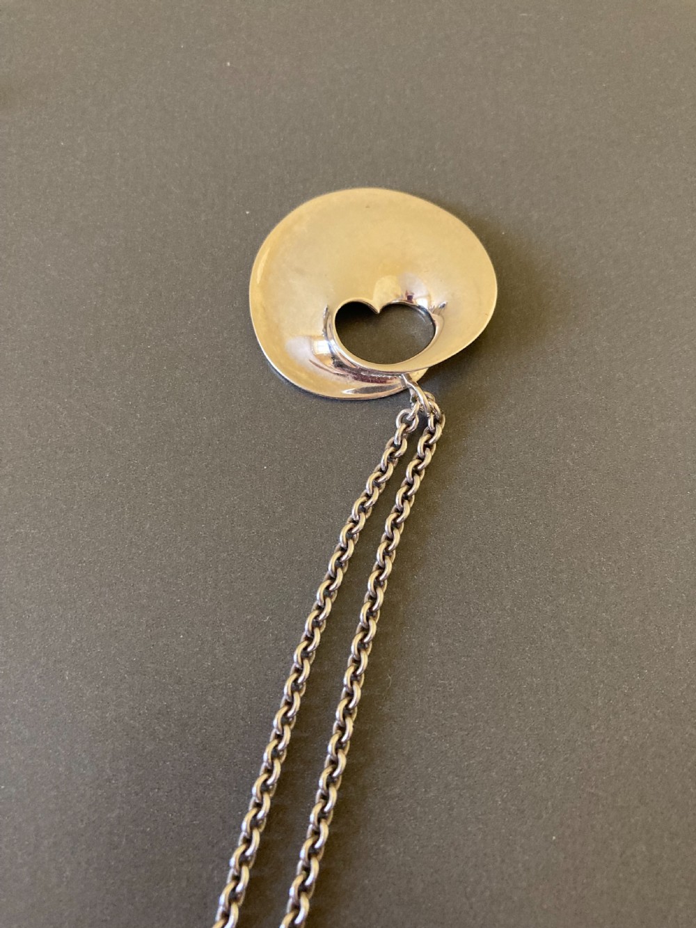 A sterling silver circular pendant featuring an organic cutout design attached to a double fine silver chain. View VIII