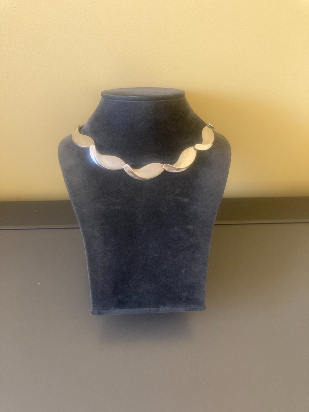 A Georg Jensen 1960s Danish sterling silver necklace featuring contoured, wave-like articulated links arranged in a circular shape. View III