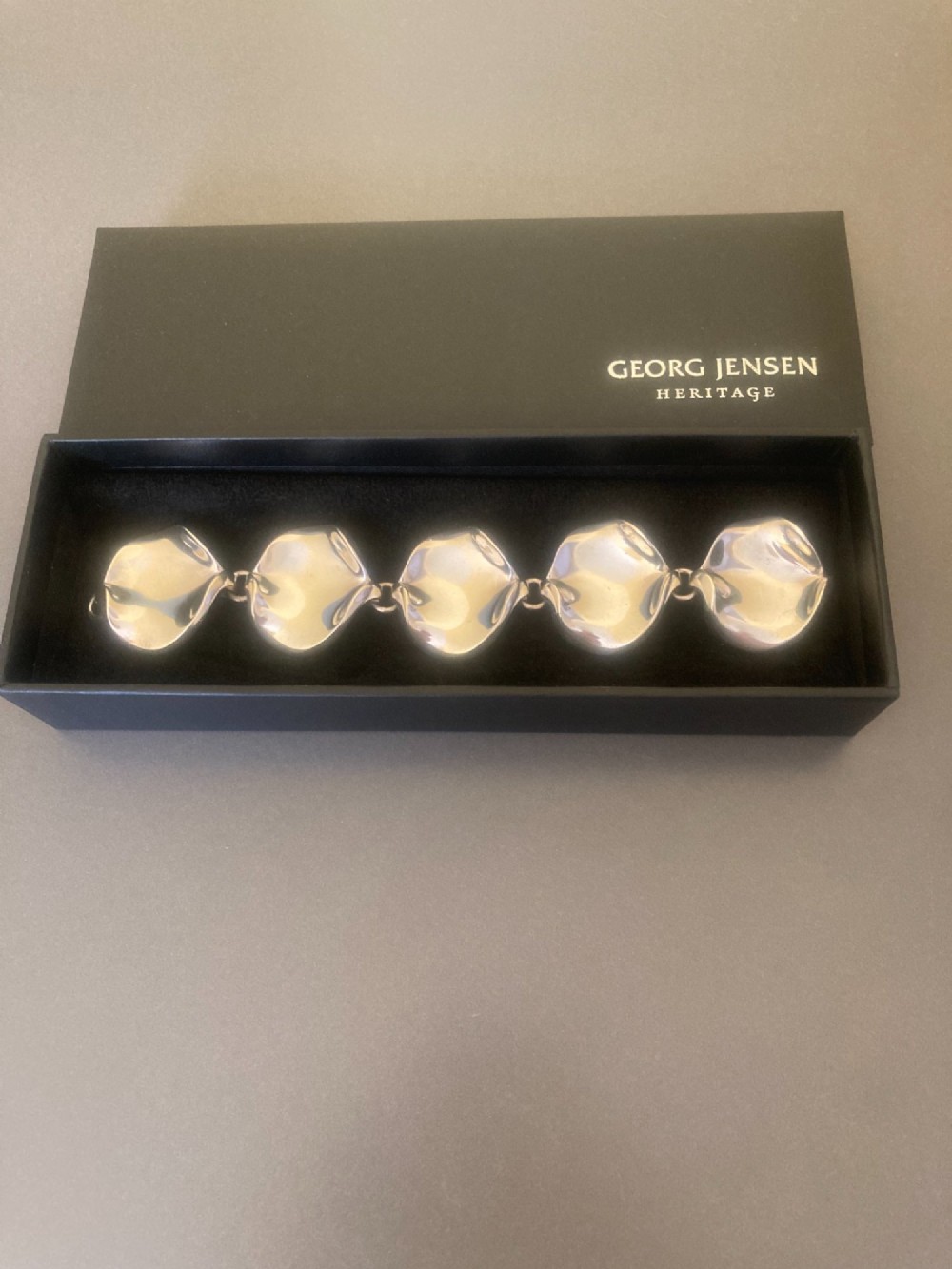 A 1960s Georg Jensen sterling silver link bracelet featuring five organic, undulating petal-formed links joined by small silver rings. View V