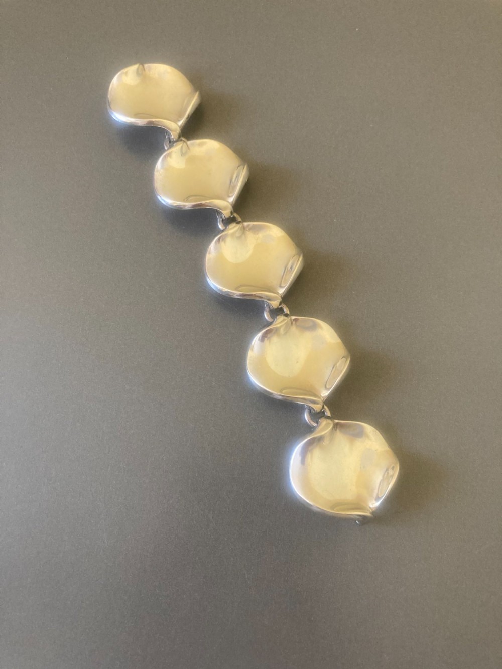 A 1960s Georg Jensen sterling silver link bracelet featuring five organic, undulating petal-formed links joined by small silver rings. View VII