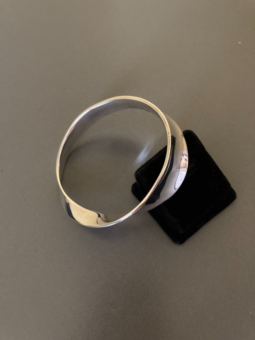 A polished sterling silver Mobius bangle featuring a continuous twisted geometric loop. View III