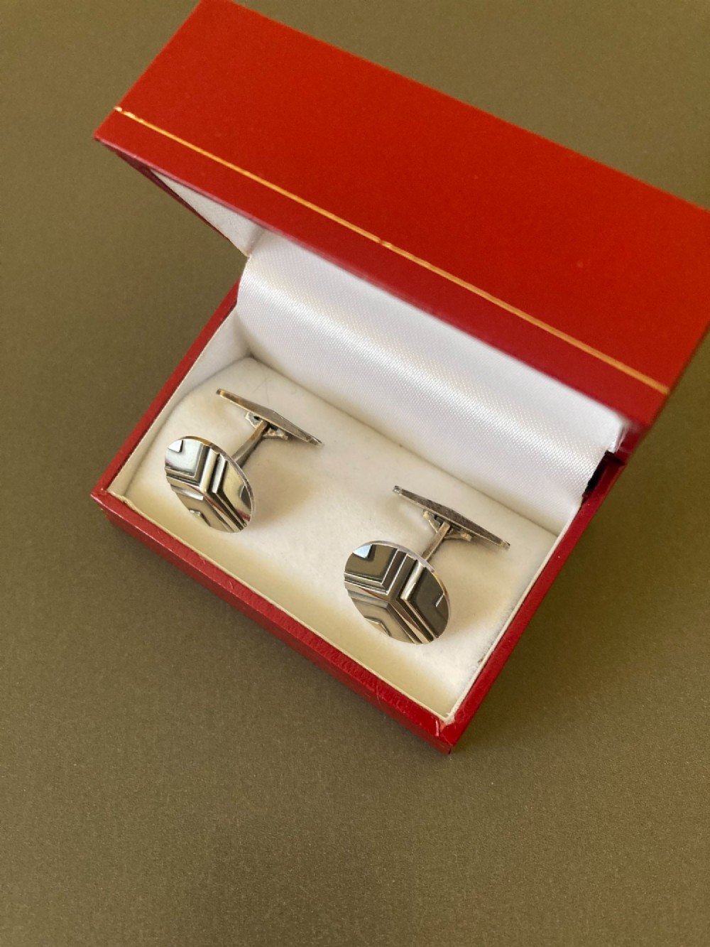 A pair of round sterling silver cufflinks featuring a stylized geometric chevron design with oxidised accents. View II