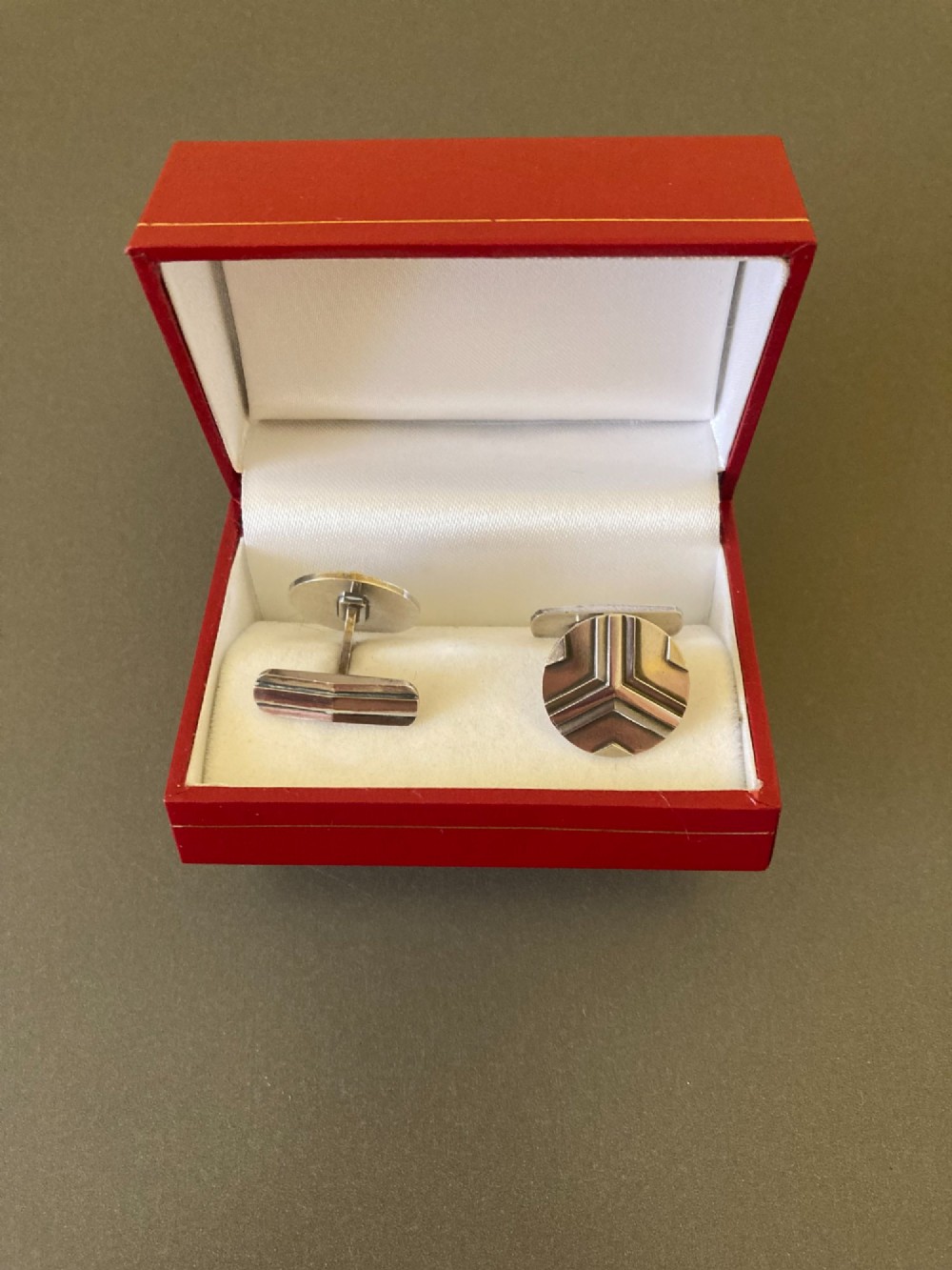 A pair of round sterling silver cufflinks featuring a stylized geometric chevron design with oxidised accents. View VI