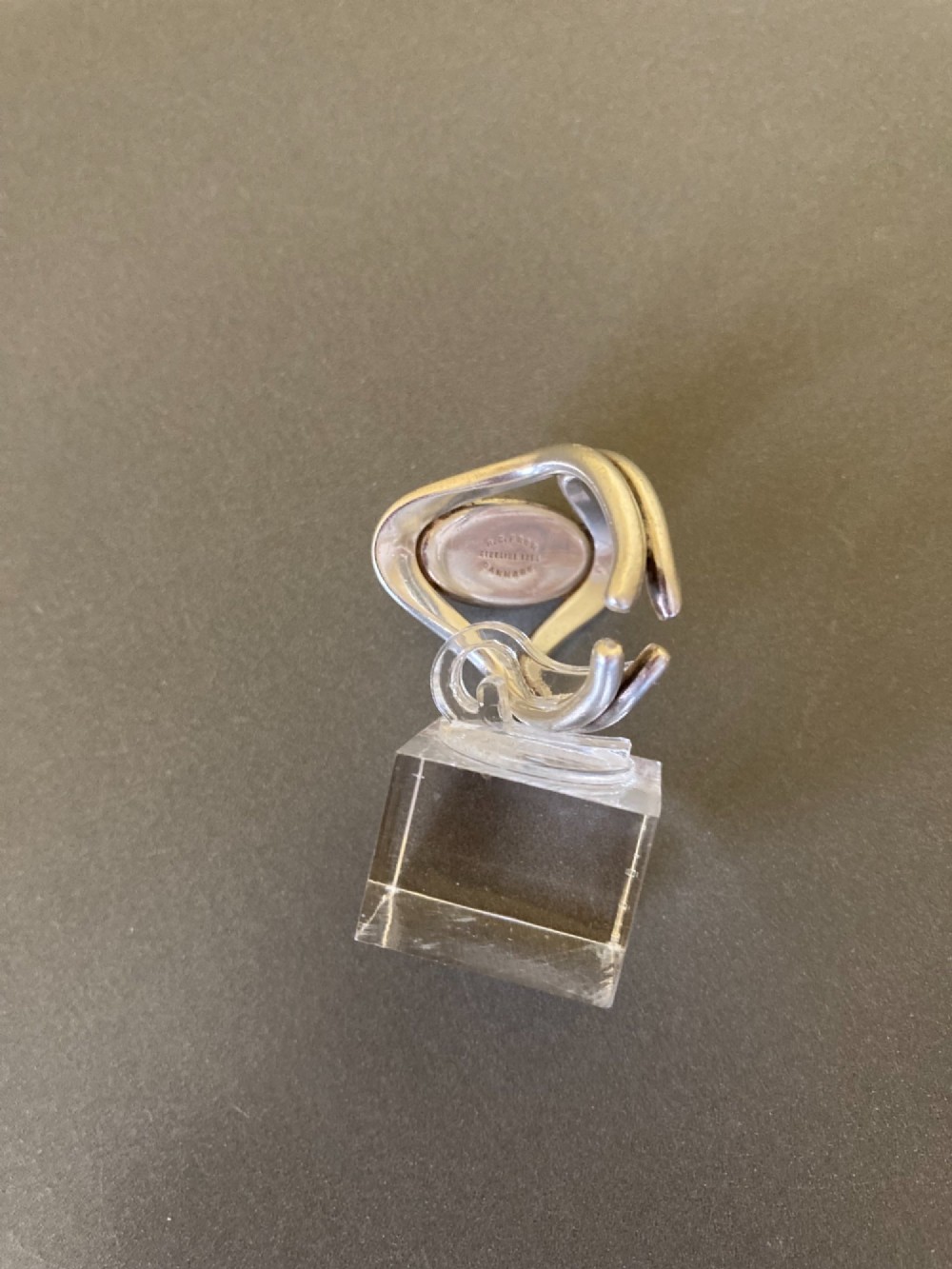 A mid-century Danish sterling silver ring featuring a central oval cabochon amber stone enclosed within a sculptural split-band frame. View VI