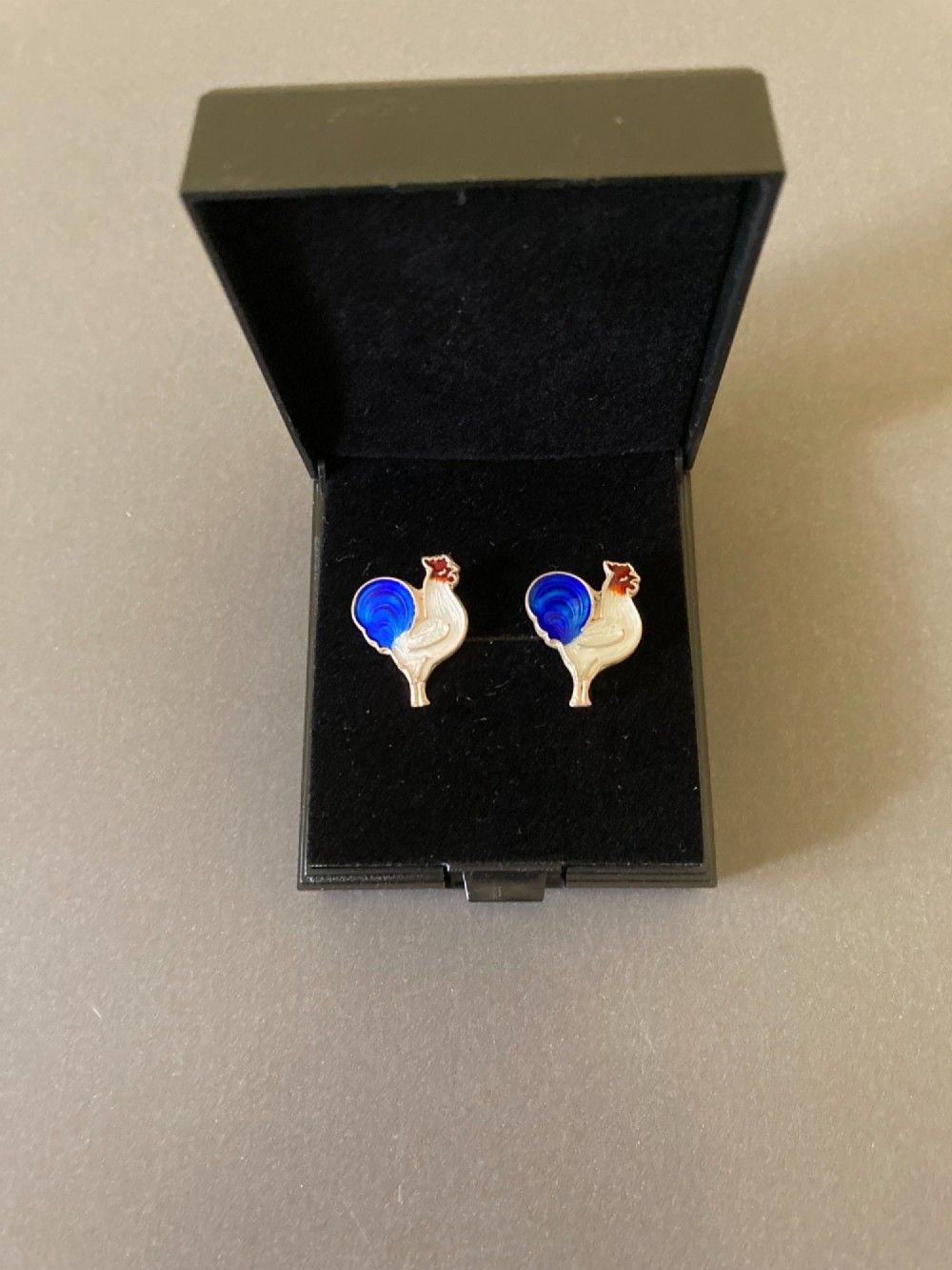 A pair of 1950s Danish sterling silver and enamel cufflinks shaped as cockerels with blue tails and white enamel bodies.