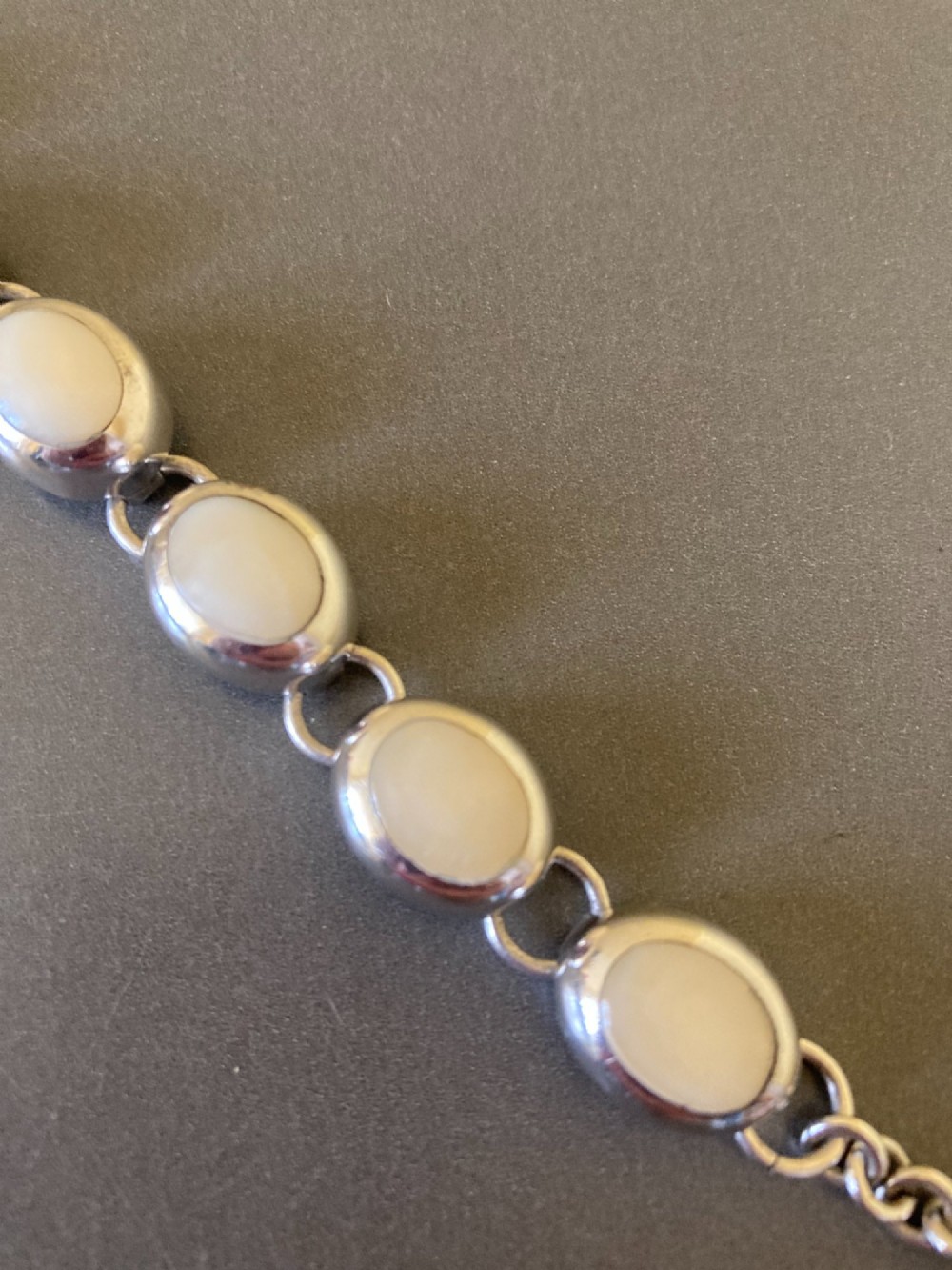 A Mexican sterling silver link bracelet featuring eight oval cabochon moonstones set in polished bezels with a toggle clasp attachment. View II