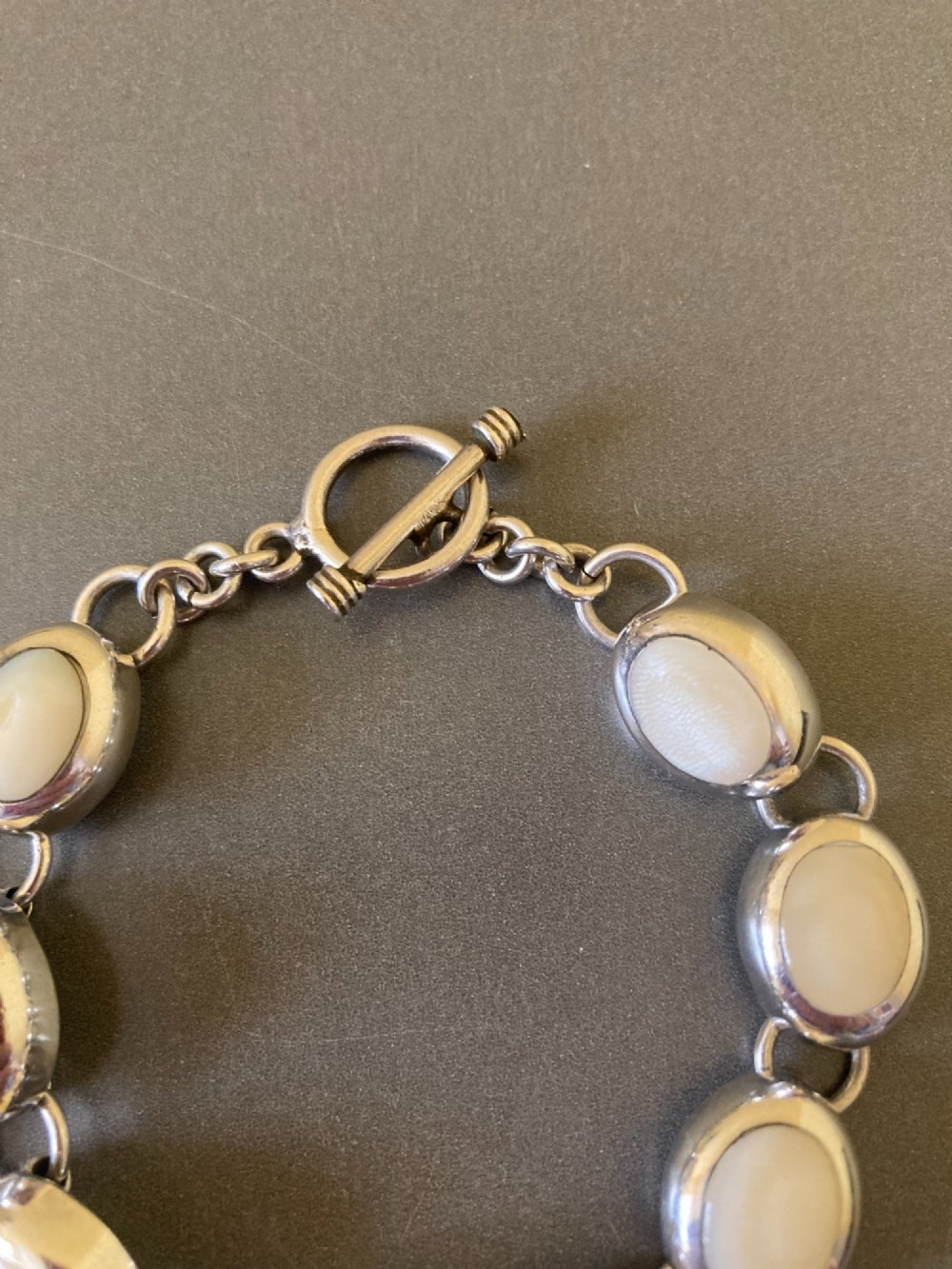 A Mexican sterling silver link bracelet featuring eight oval cabochon moonstones set in polished bezels with a toggle clasp attachment. View V
