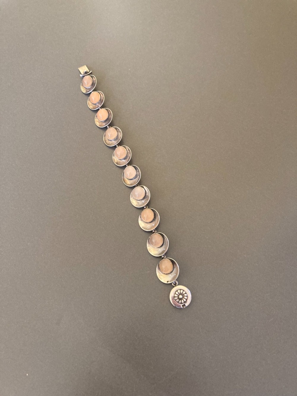 A Danish modernist sterling silver link bracelet set with round pale pink rose quartz cabochons in concaved circular mounts with a floral-detailed clasp. View II