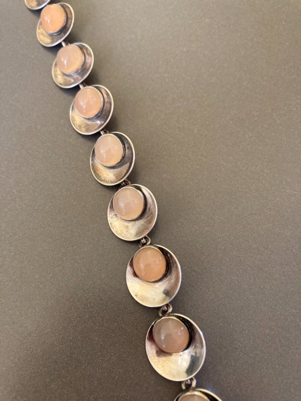 A Danish modernist sterling silver link bracelet set with round pale pink rose quartz cabochons in concaved circular mounts with a floral-detailed clasp. View III