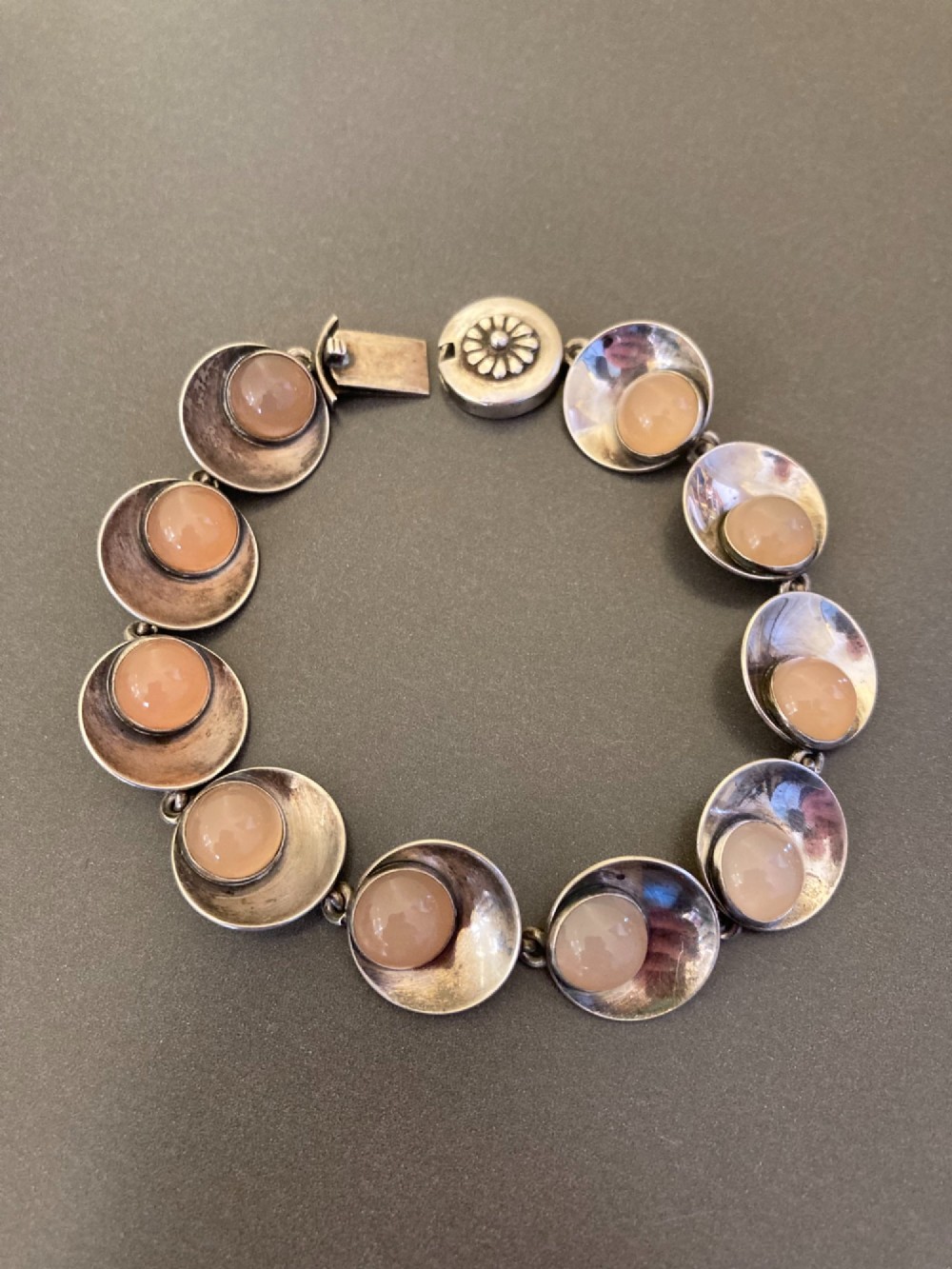 A Danish modernist sterling silver link bracelet set with round pale pink rose quartz cabochons in concaved circular mounts with a floral-detailed clasp. View IV