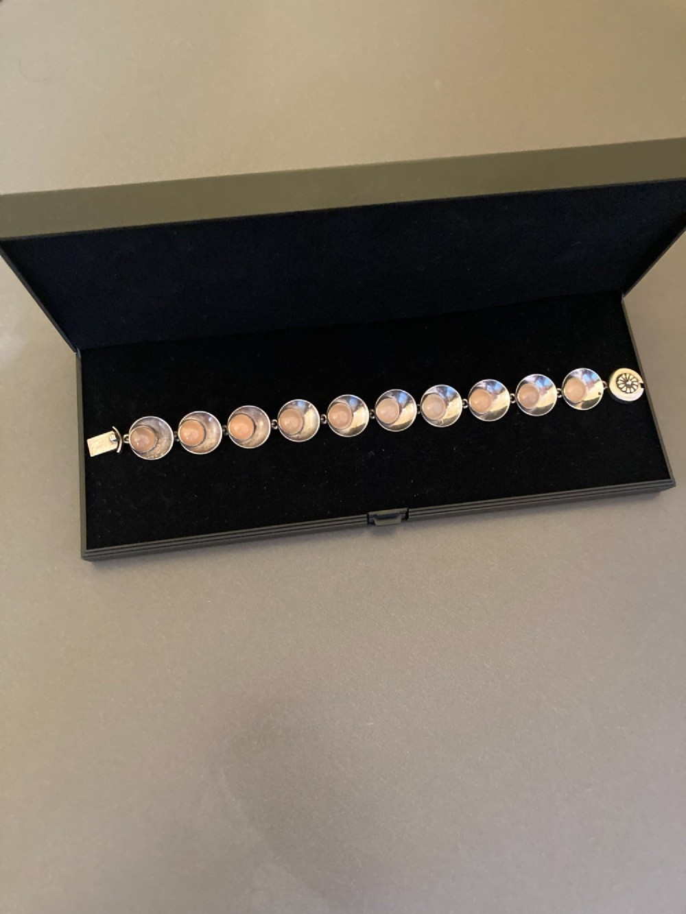 A Danish modernist sterling silver link bracelet set with round pale pink rose quartz cabochons in concaved circular mounts with a floral-detailed clasp. View V