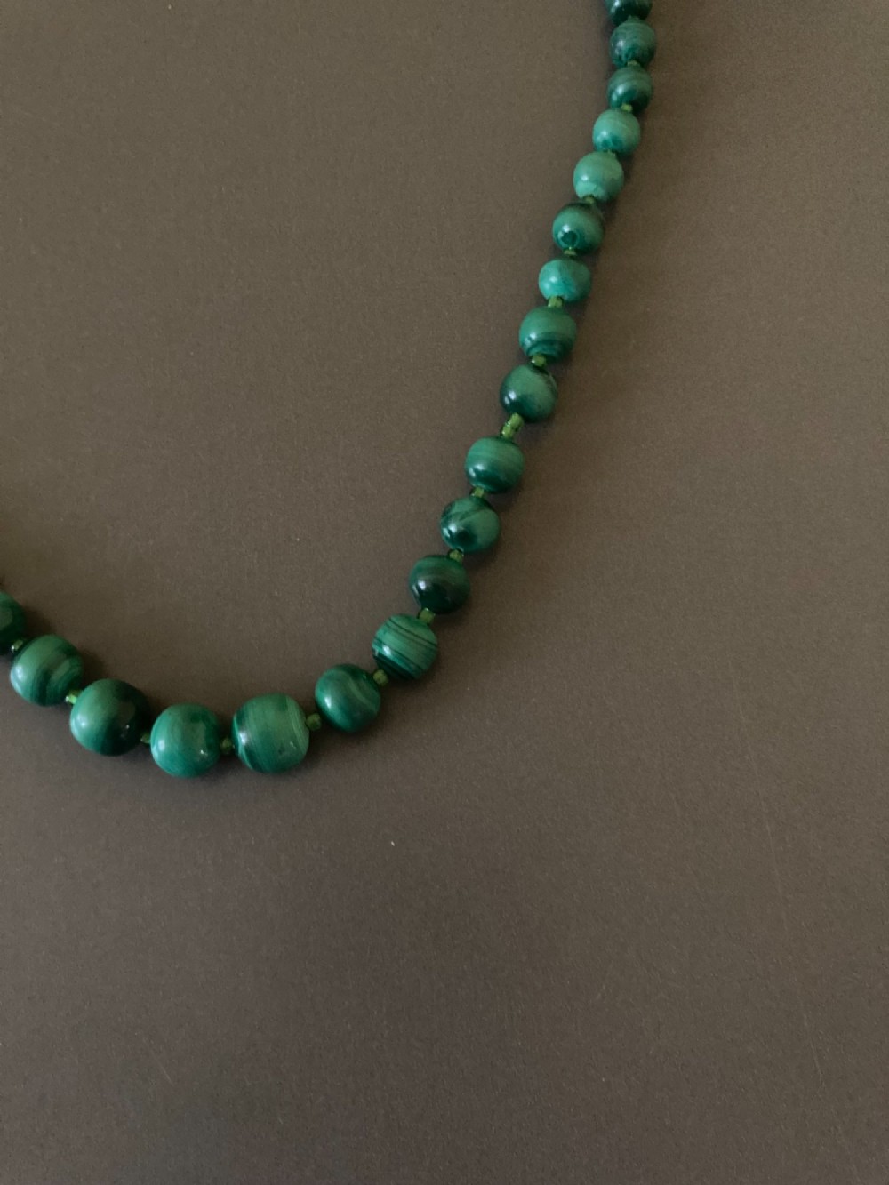 A 1950s strand of graduated, polished green malachite beads arranged in a heart shape with a brass screw clasp. View IV
