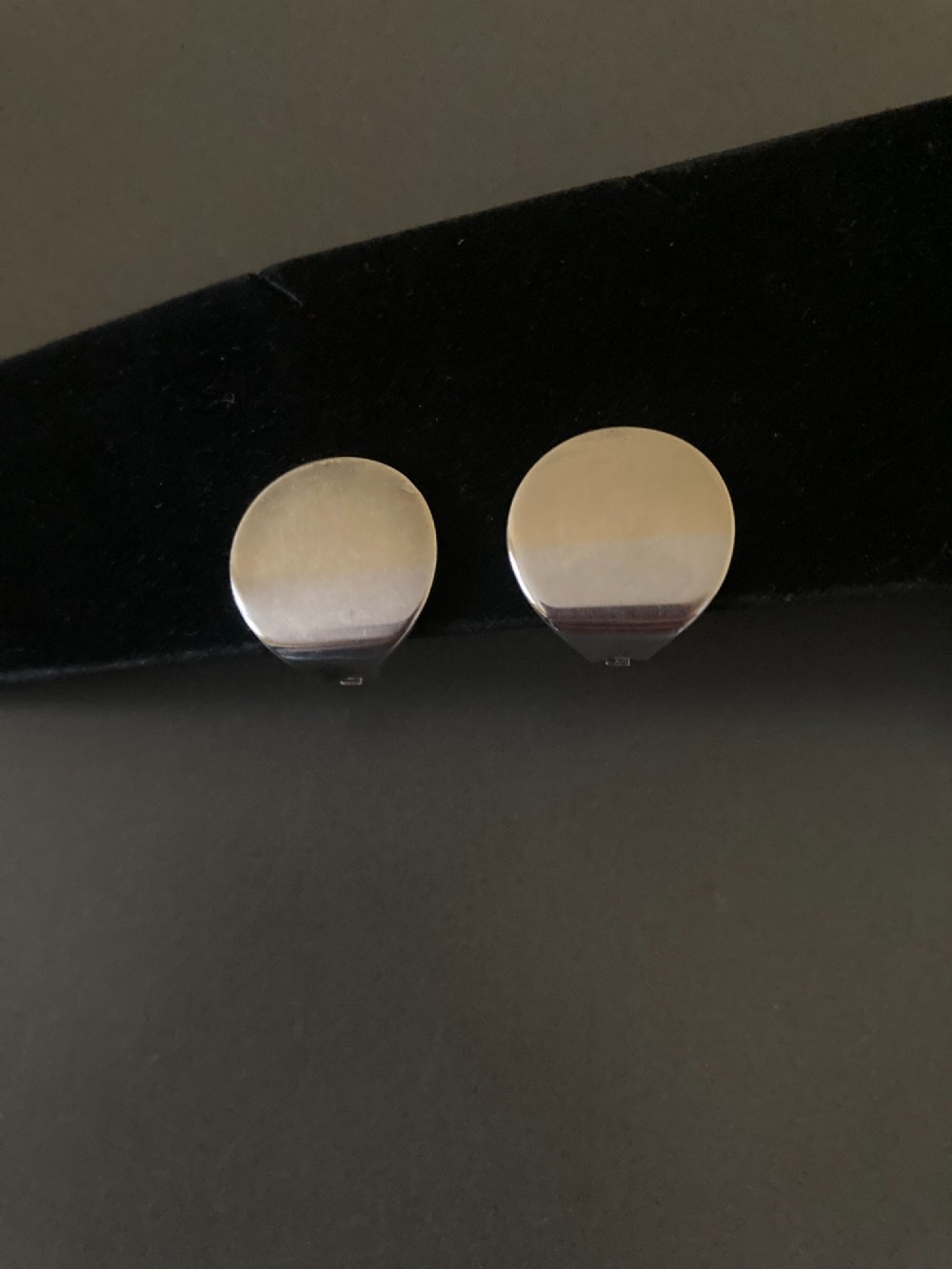 A pair of circular Danish sterling silver clip-on earrings featuring a smooth, minimalist curved profile. View II