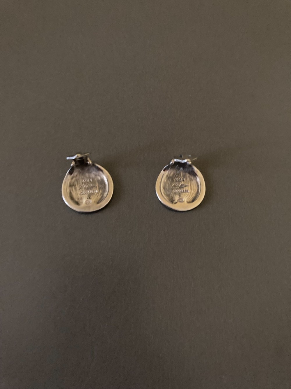 A pair of circular Danish sterling silver clip-on earrings featuring a smooth, minimalist curved profile. View III