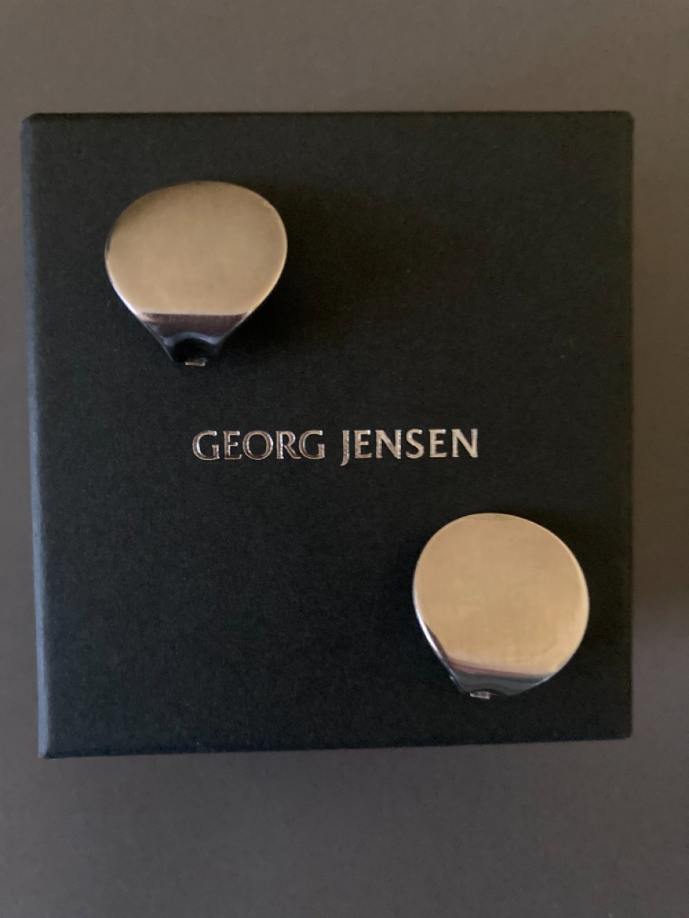 A pair of circular Danish sterling silver clip-on earrings featuring a smooth, minimalist curved profile. View VI