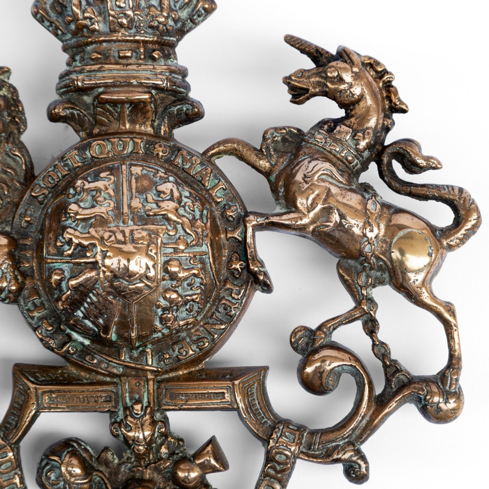 A cast brass wall plaque depicting the British Royal Coat of Arms featuring a lion and unicorn flanking a central shield and crown. View III