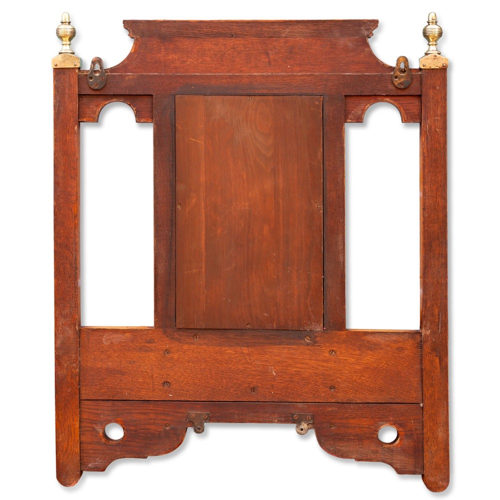 A wall-mounted golden oak coat rack featuring brass hooks, brass finials, a central bevelled mirror, and a small central storage box. View IV