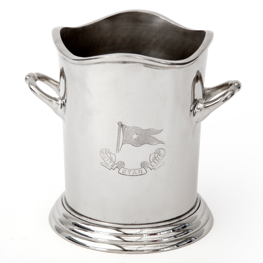 A silver-plated twin-handled wine cooler featuring a shaped rim, stepped base, and an engraved flag logo on the side.