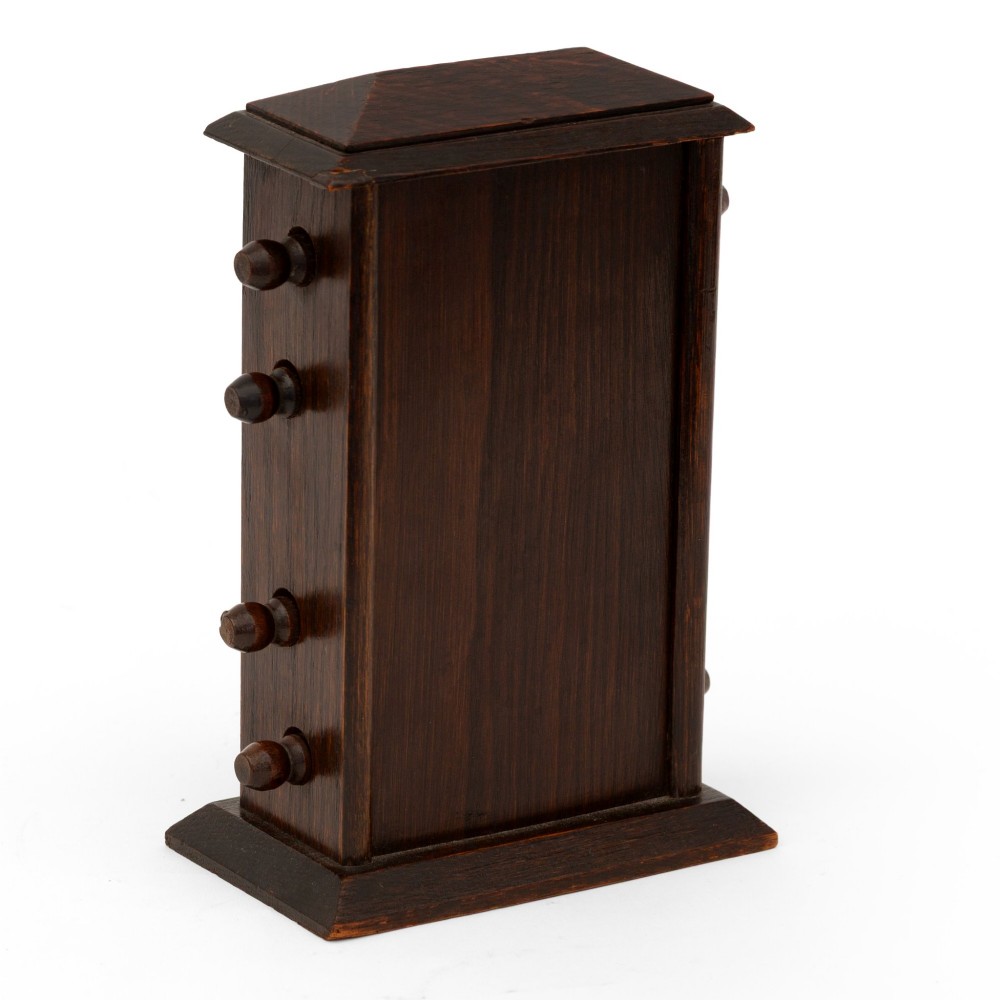 A dark oak desktop perpetual calendar with turned side knobs and apertures displaying the day, date, and month. View III