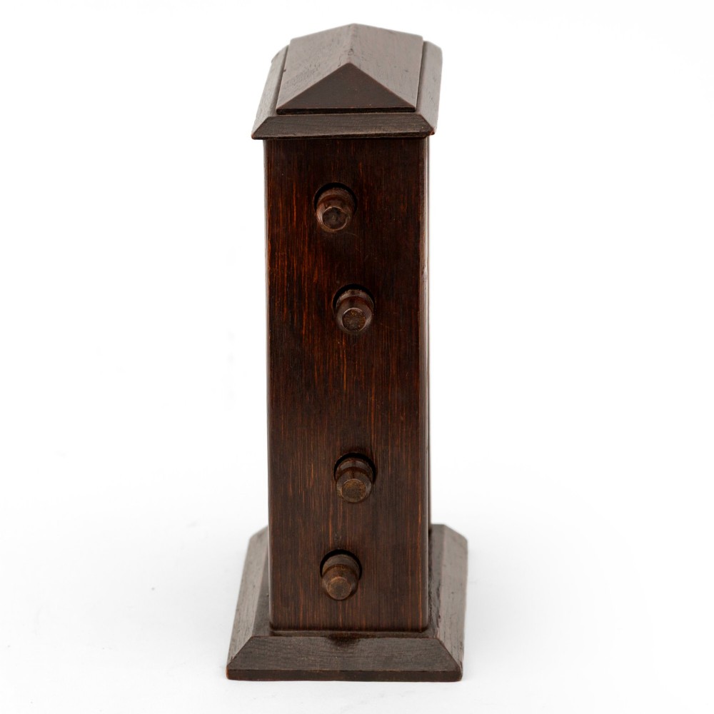 A dark oak desktop perpetual calendar with turned side knobs and apertures displaying the day, date, and month. View IV
