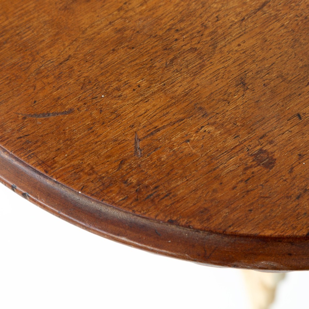 A Victorian cast iron tripod table featuring an off-white painted base with scroll motifs and a circular dark wood top with a scalloped edge. View IV