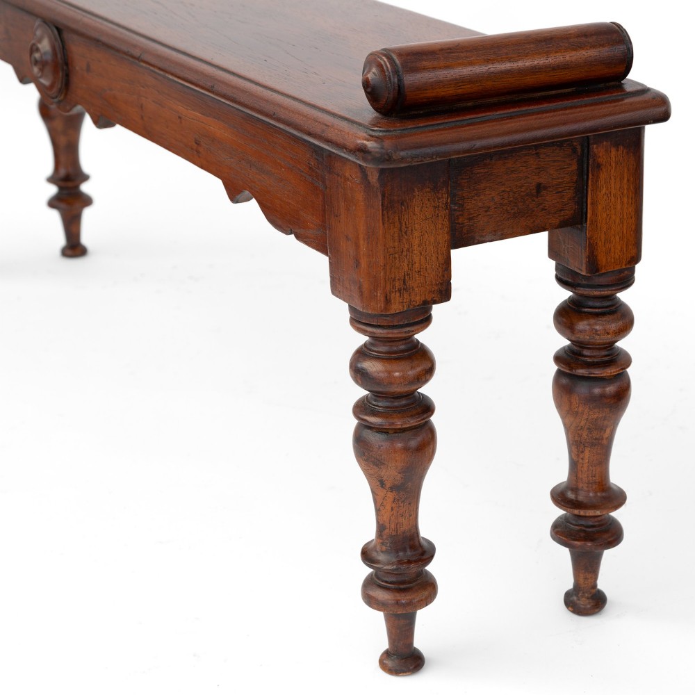 A long polished mahogany hall bench featuring turned legs, cylindrical bolster ends, and a central carved rosette on the apron. View IV