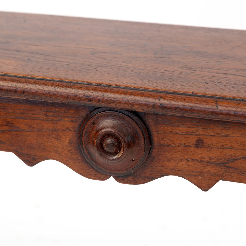 A long polished mahogany hall bench featuring turned legs, cylindrical bolster ends, and a central carved rosette on the apron. View V