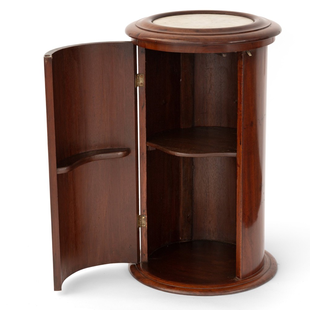 A Victorian cylindrical figured mahogany pot cupboard featuring a single curved door and an inset marble top. View II