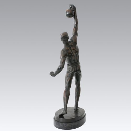 fig 2. An Art Deco dark patinated bronze sculpture depicting a muscular male figure lifting a weight overhead on an oval dark base.
