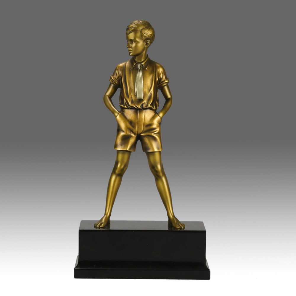 An Art Deco bronze sculpture depicting a standing young boy with hands in his pockets, mounted on a rectangular black marble plinth.