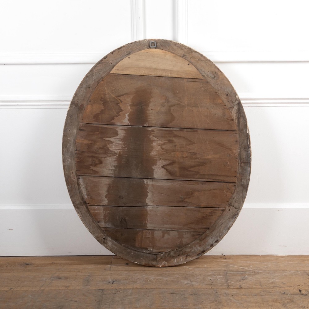 A 19th-century oval wall mirror featuring a silvered moulding frame with beaded rim detail and aged glass showing natural foxing. View III