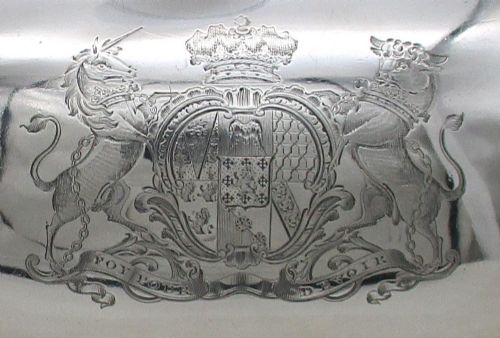 fig 1. An oval Regency era Old Sheffield Plate domed meat cover featuring a decorative cast handle, engraved coat of arms, and gadrooned border.